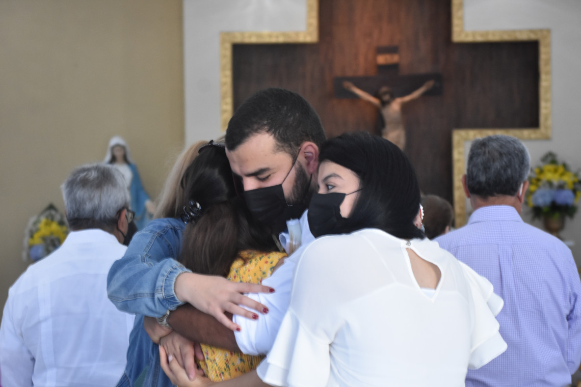 Padres abrazando a su hijo en su bautismo