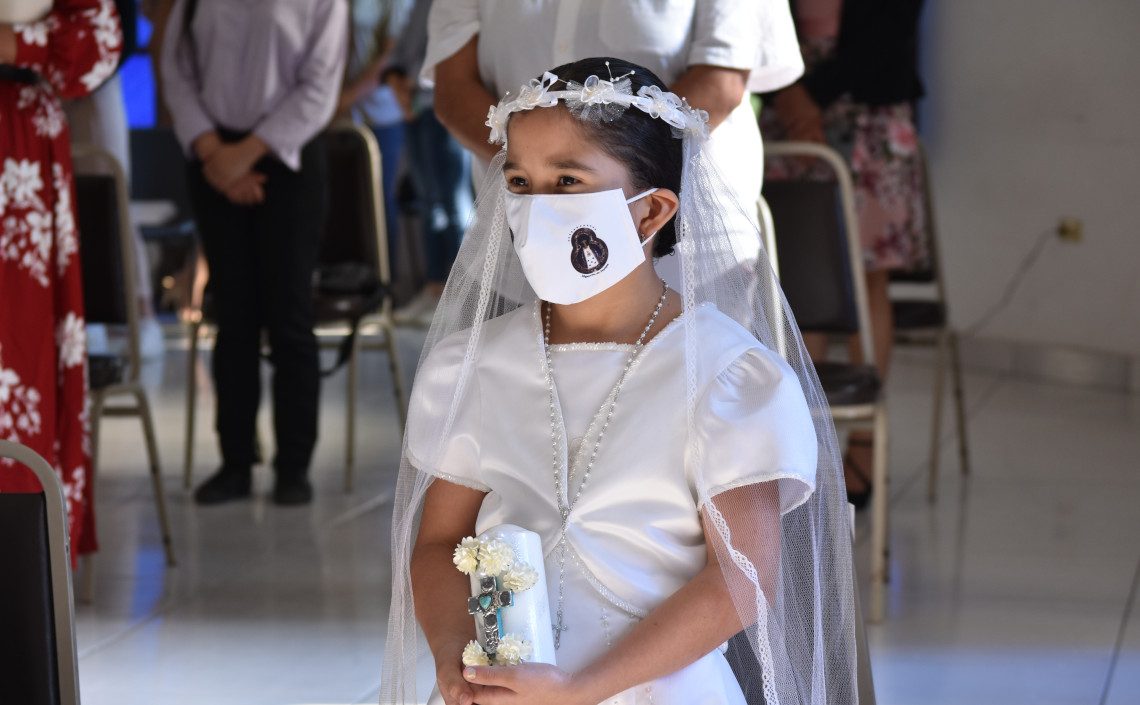 Niña sonriendo en su primera comunión