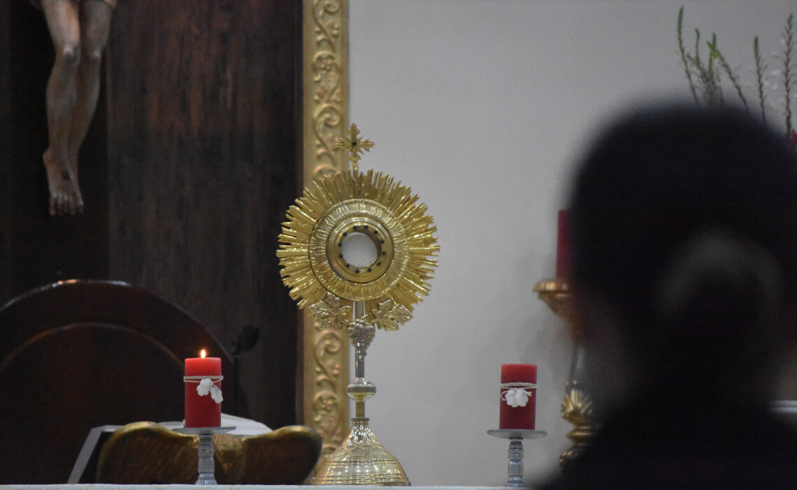 Mujer frente al Santísimo Sacramento del altar